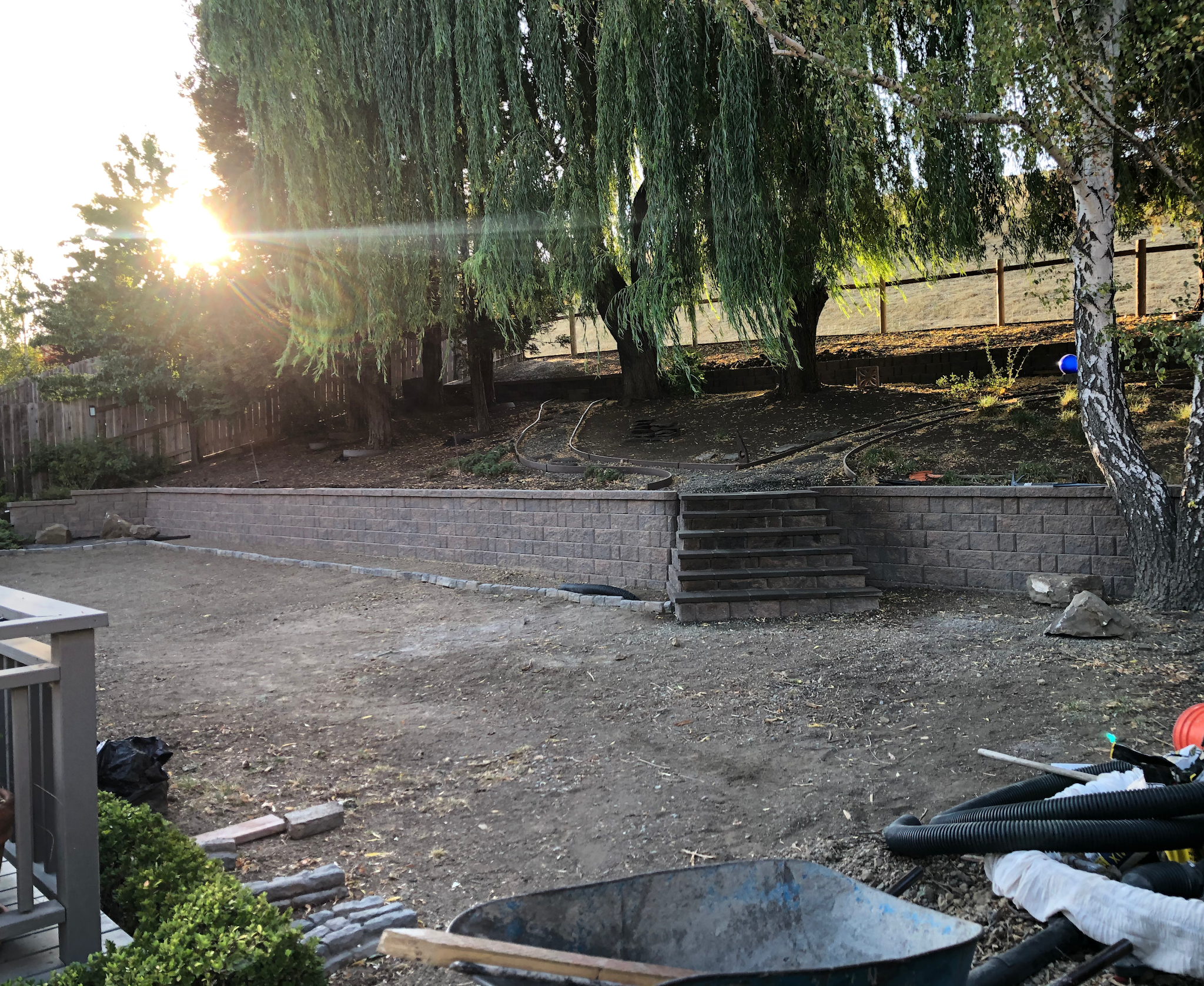 Stone retaining wall and staircase built by A&F Landscaping in a sloped backyard